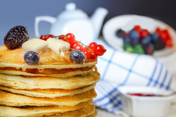 A stack of pancakes with blueberry and currant and blackberry