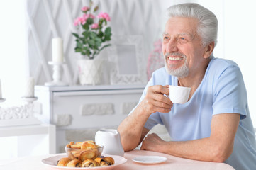 smiling senior man drinking tea at home 