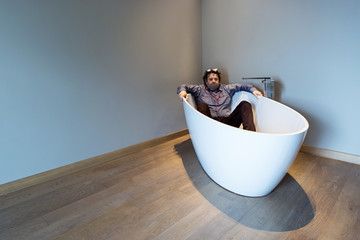 Man inside a luxury bathtub in modern apartment