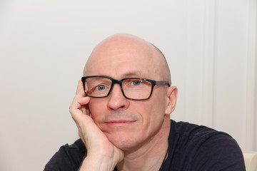 Adult bold man with crooked glasses