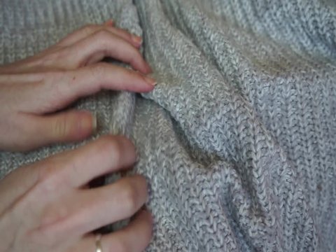Manos de una mujer tocando tela de lana