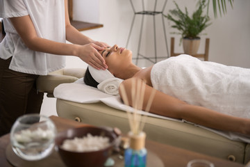 Obraz na płótnie Canvas Thai massage. Attractive relaxed woman being in the spa salon while enjoying Thai massage
