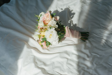 Wedding morning composition of the great flower bouquet for bride on the bed