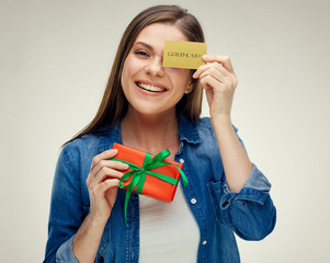Smiling woman holding credit card near eye.