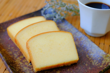 Homemade plain butter cake soft and moist. Slice of butter cake on plate and serve with black...