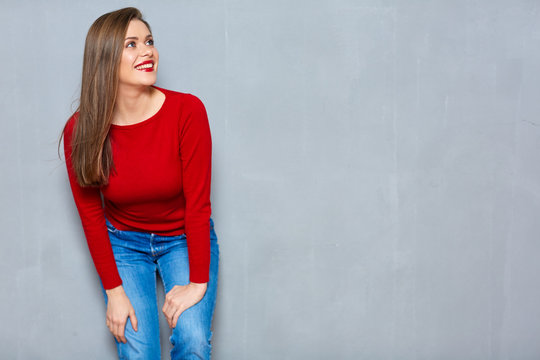 Casual clothes dressed smiling girl standing on gray wall backgr