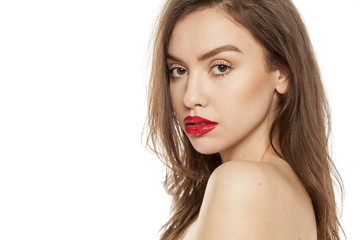 Naklejka premium Young beautiful woman posing with red lipstick on her lips, on white background