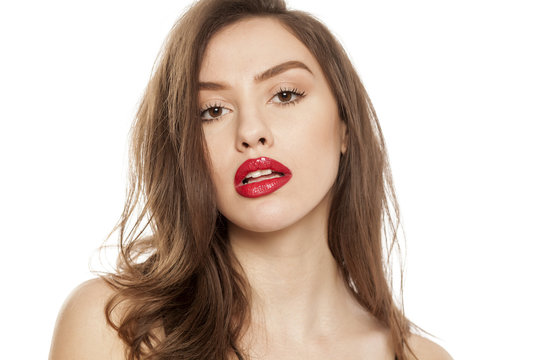 Young beautiful woman posing with red lipstick on her lips, on white background