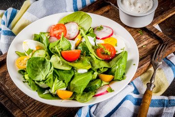 Fresh spring vegetable salad, dark concrete background copy space