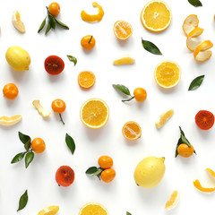 Creative flat layout of fruit, top view. Sliced orange, lemon, persimmon, tangerine, green leaves isolated on white background. Food wallpaper, composition pattern of fresh fruits.