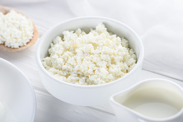 close-up view of fresh organic cottage cheese and milk in jug on wooden table