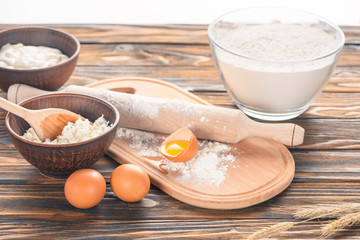 close-up view of cottage cheese, eggs and flour on wooden table