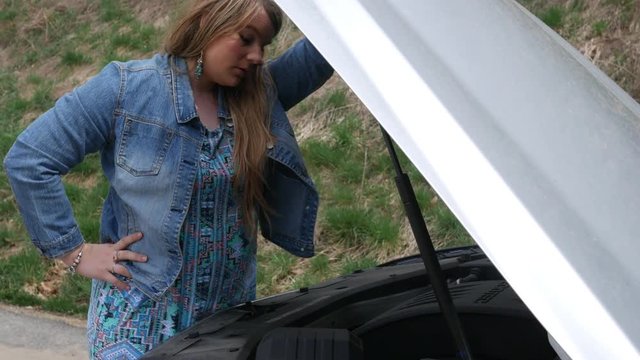 A woman is a upset that once again she is having car engine problems