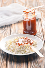 close-up view of tasty healthy cottage cheese with jam on wooden table