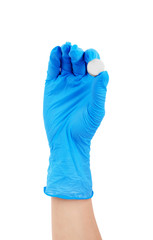 Hands in rubber gloves holding pills on white background