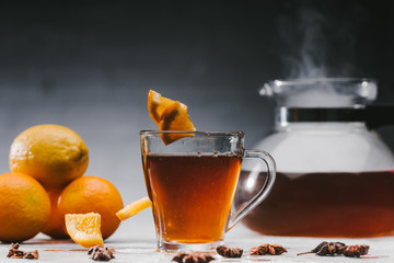 Black tea in cup with lemons and star anise on table