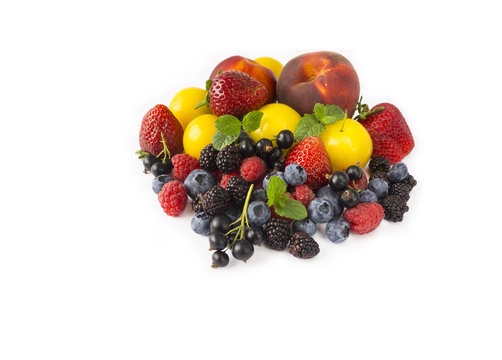 Fruits and berries isolated on white background. Ripe strawberries, blackberries, bluberries, peaches and yellow plums. Sweet and juicy fruits at border of image with copy space for text. Top view.