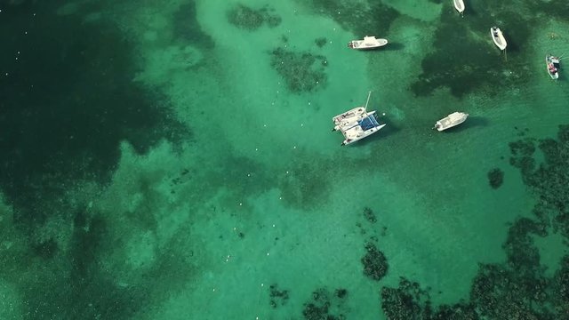 Tourist boats and diving people. A bay in the Caribbean Sea. Aerial view. Beautiful turquoise water and underwater coral reef. Shooting from the drone