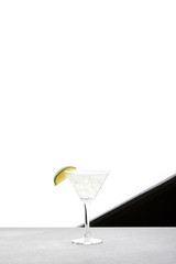 close up view of margarita cocktail with lime and ice on tabletop on black and white backdrop