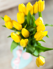 Obraz premium Yellow tulips on wooden background