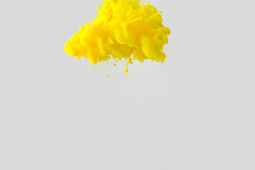 close up view of bright yellow paint splash in water isolated on gray