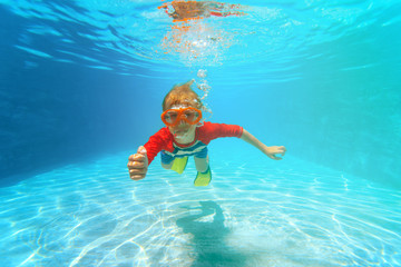happy little boy swim underwater with thumbs up