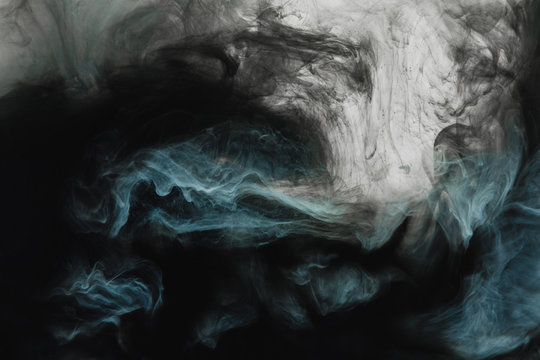 full frame image of mixing of light gray, turquoise and black paints splashes  in water isolated on gray