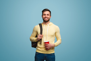 Stylish guy with backpack and cup