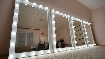 Four make-up mirrors stand in the room and are lit.