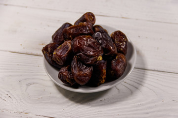 Dried dates fruit on white wooden table