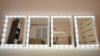 Four make-up mirrors stand in the room and are lit. Mirrors turn on in turn.