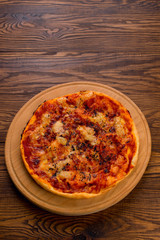 Appetizing Homemade Pizza with cheese on a wooden background