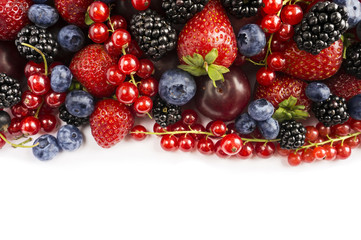 Berries and fruits with copy space for text. Black-blue and red food. Ripe blackberries, blueberries, strawberries, red currants and plums on white background. Top view.