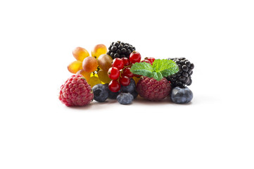 Ripe blueberries, blackberries, red currants, grapes, raspberries with a mint leaf. Various fresh summer berries on white background. 