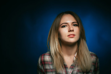 portrait smiling girl on blue background in studio