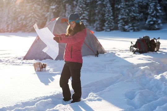 Woman looking at map in snowy landscape