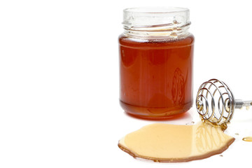 A glass of honey with dipper on a white background. copy space