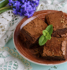 square pieces of chocolate brownie on a brown round plate