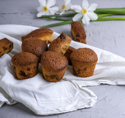 small round baked muffins with dry fruits and raisins on a white textile napkin