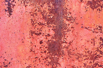 A sheet of old rusty metal painted with red cracked paint. Abstract background. Metallic background.