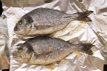 Grilled whole dorado fish cooked on foil