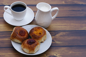 home-made scones with different jams, coffee and  jug milk on wooden table closeup