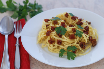 spaghetti with sun-dried red tomatoes and parsley close-up.