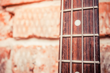 old bass guitar on brick wall background
