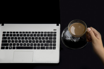 Close-up businessman working at and use a laptop and drink coffee.