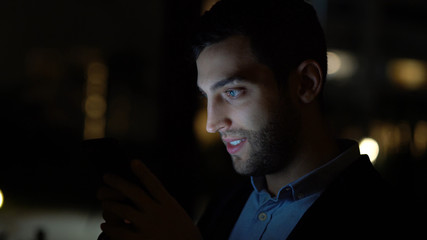 Business man using mobile at nighttime