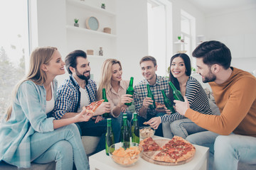 Cheerful, stylish, attractive, positive community sitting in livingroom, house having snacks on the table speaking talking spending free time together enjoying weekend