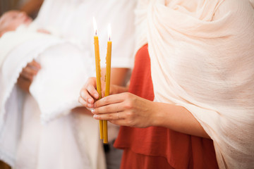 Woman hold in hands two candels in church atmosphere