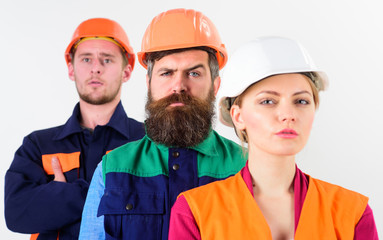 Serious team of three constructor workers in hard hats