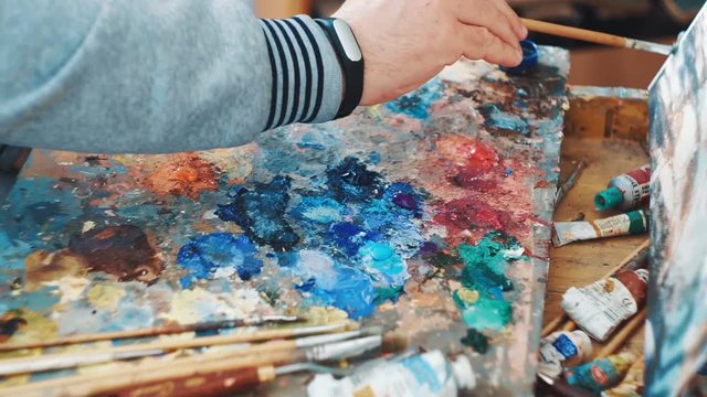 Artist mixes paints on the palette